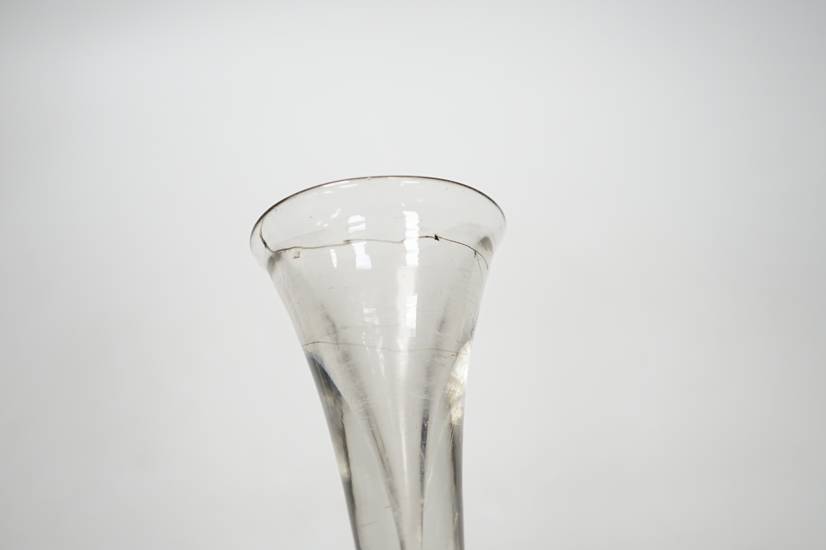 An English lead crystal baluster toastmaster’s glass, c.1710-20, elongated trumpet deceptive bowl on triple flattened annular knop, plain teared section includes a basal knop, conical folded foot, 15cm high